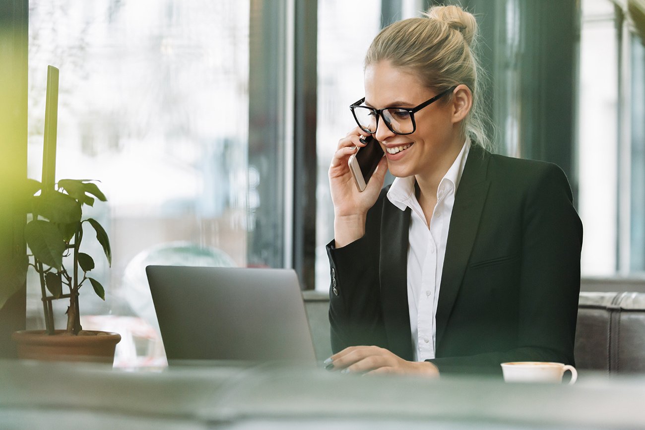 smiling-blonde-business-woman-talking-by-mobile-phone